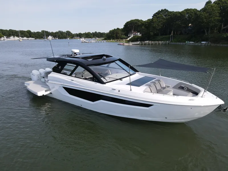 Slide: The Image of 2025 Cruisers Yachts 50 GLS Outboard on a serene lake. - 11