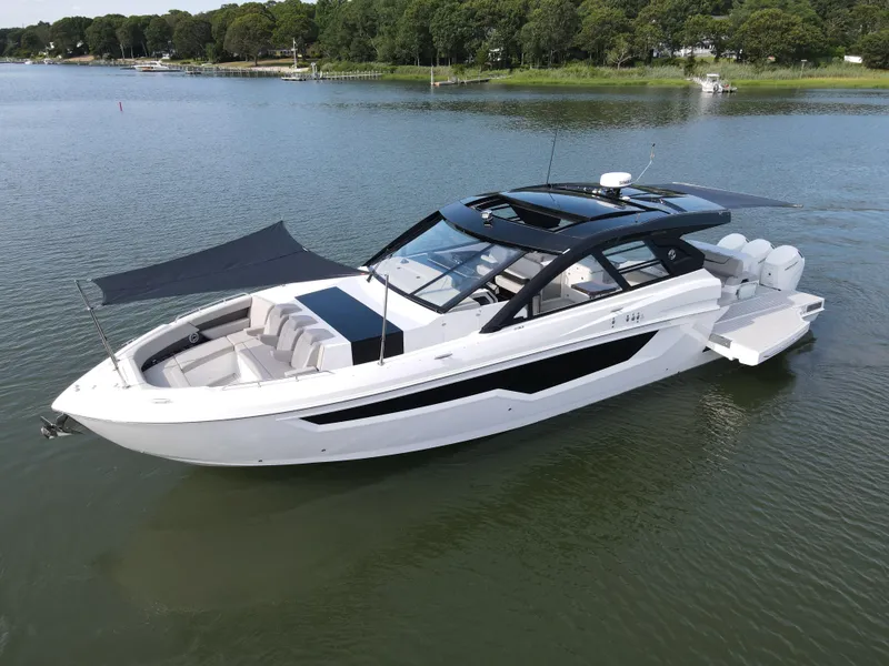 Slide: The Image of 2025 Cruisers Yachts 50 GLS Outboard luxury boat on a serene lake. - 13