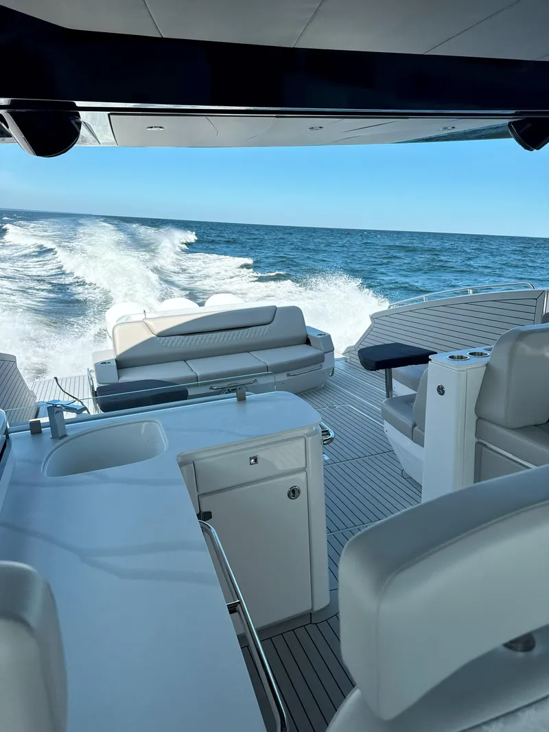 Slide: The Image of 2025 Cruisers Yachts 50 GLS Outboard cruising on open water, featuring luxurious seating and amenities. - 14