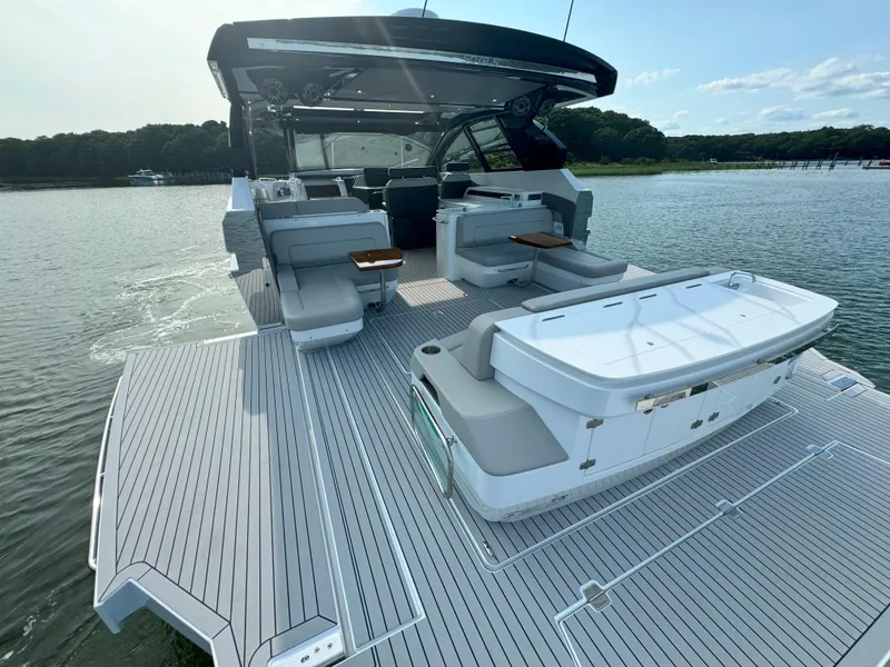 Slide: The Image of 2025 Cruisers Yachts 50 GLS Outboard, spacious deck, luxury seating, on calm water. - 15