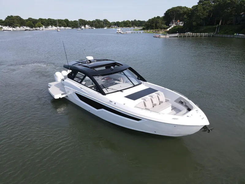Slide: The Image of 2025 Cruisers Yachts 50 GLS Outboard luxury boat on a serene lake. - 2