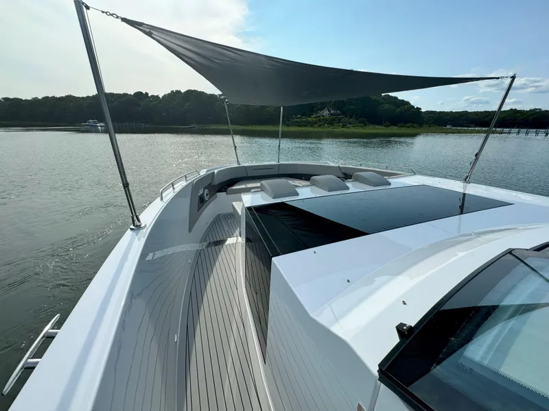 Slide: The Image of 2025 Cruisers Yachts 50 GLS Outboard, spacious deck with sunshade on calm waters. - 24