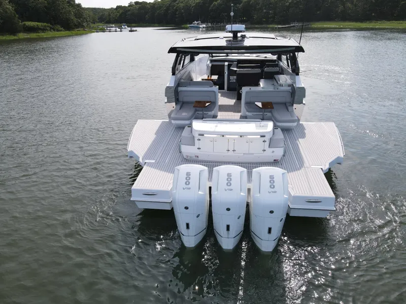 Slide: The Image of 2025 Cruisers Yachts 50 GLS Outboard on water, rear view with triple engines. - 4