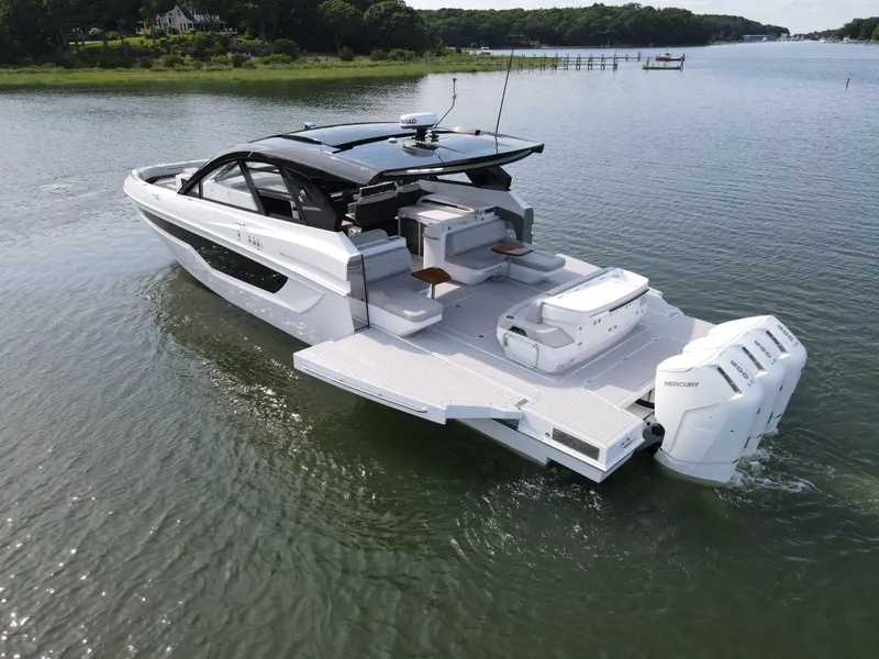 Slide: The Image of 2025 Cruisers Yachts 50 GLS Outboard luxury boat on a serene lake. - 5