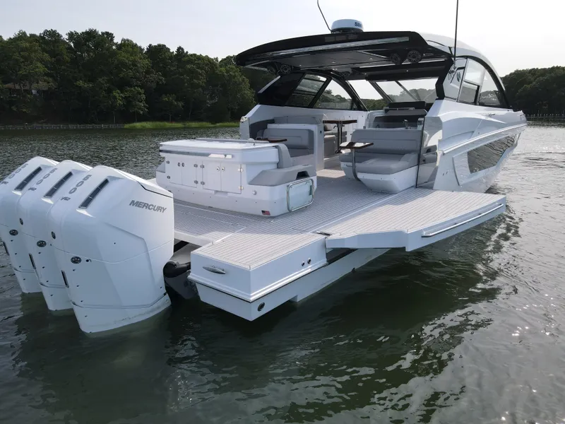 Slide: The Image of 2025 Cruisers Yachts 50 GLS Outboard on water, rear view with triple Mercury engines. - 9