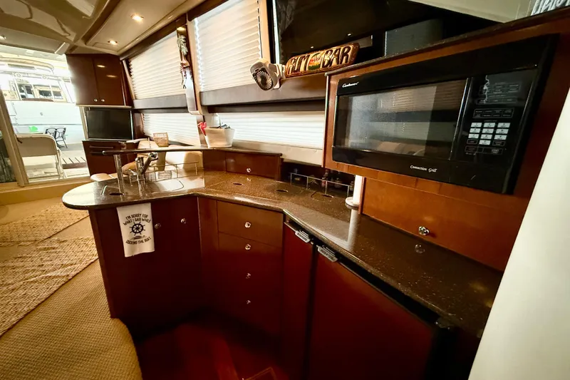 Slide: The Image of 2011 Meridian 391 Sedan yacht kitchen with microwave, sink, and wooden cabinetry. - 20