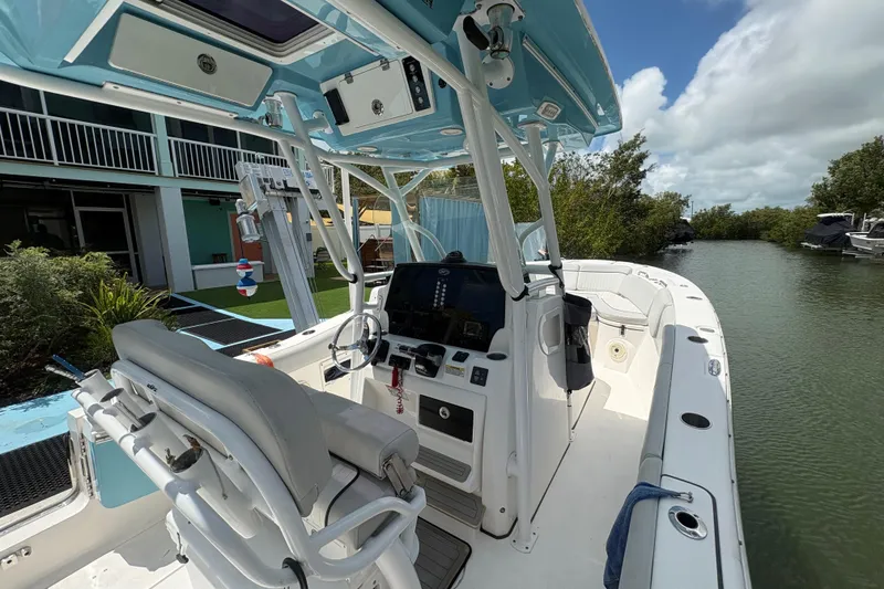Slide: The Image of 2021 Sea Fox 268 Commander boat docked by a canal, featuring a modern helm and seating. - 7