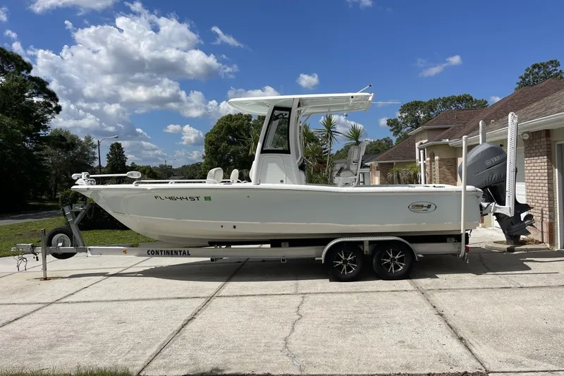 Slide: The Image of 2020 Sea Hunt BX 25 FS boat on trailer, parked in driveway under blue sky. - 10