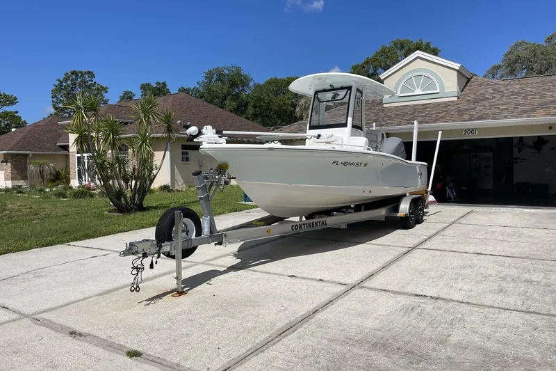 Slide: The Image of 2020 Sea Hunt BX 25 FS boat on trailer in driveway, sunny day. - 12