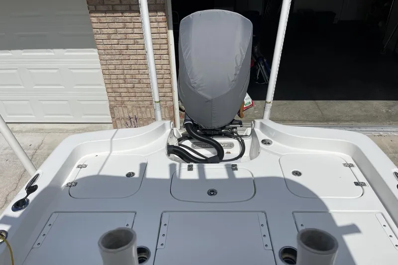 Slide: The Image of 2020 Sea Hunt BX 25 FS boat deck with covered engine, in a garage setting. - 14