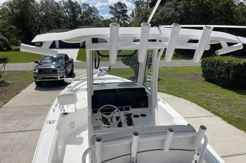 Slide: The Image of 2020 Sea Hunt BX 25 FS boat with T-top and rod holders, parked in driveway. - 15