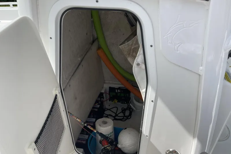 Slide: The Image of Storage compartment of a 2020 Sea Hunt BX 25 FS boat with various items inside. - 18