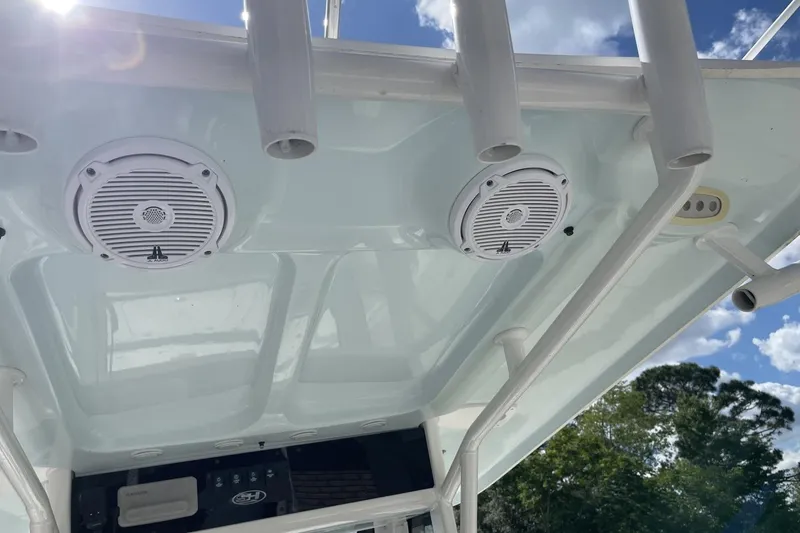 Slide: The Image of 2020 Sea Hunt BX 25 FS boat speakers and rod holders under clear blue sky. - 24