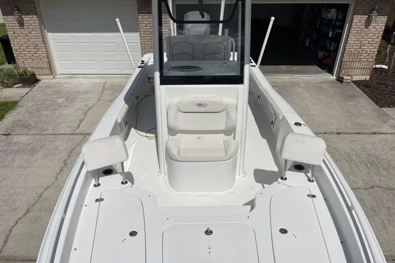 Slide: The Image of 2020 Sea Hunt BX 25 FS boat parked in driveway, showcasing spacious deck and seating. - 33