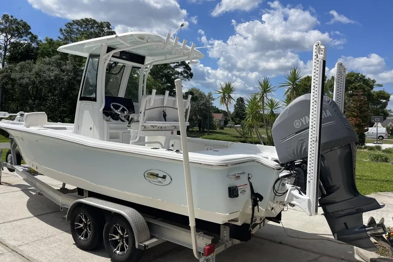 Slide: The Image of 2020 Sea Hunt BX 25 FS boat on trailer, featuring Yamaha engine, parked outdoors. - 9