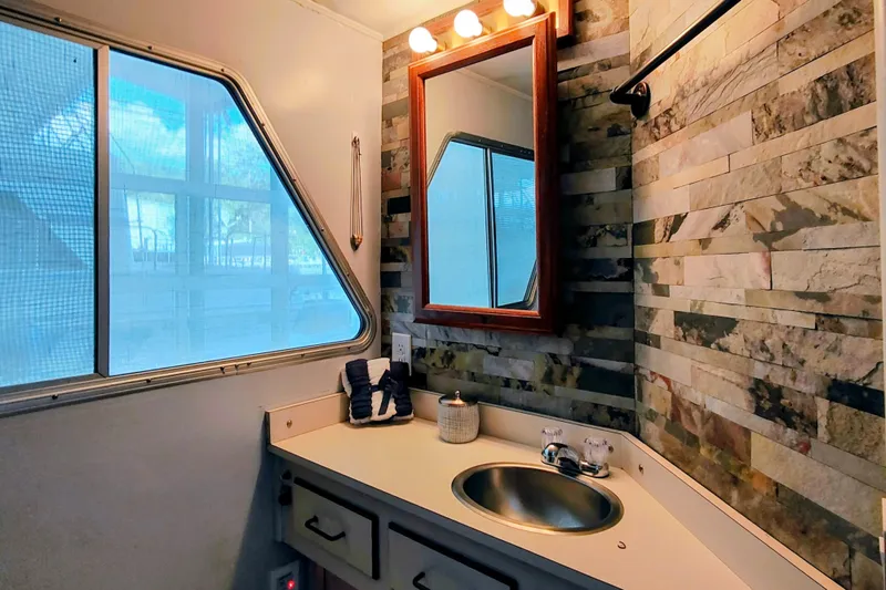 Slide: The Image of Bathroom interior of a 1988 Gibson 50 Standard with stone wall tiles and vanity mirror. - 32