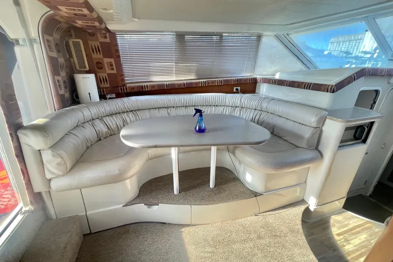 Slide: The Image of 1995 Silverton 36 Convertible yacht interior with curved seating and table. - 12