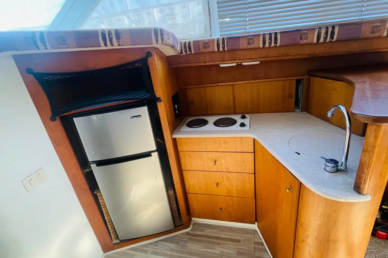 Slide: The Image of 1995 Silverton 36 Convertible yacht kitchen with fridge, stove, and sink. - 15