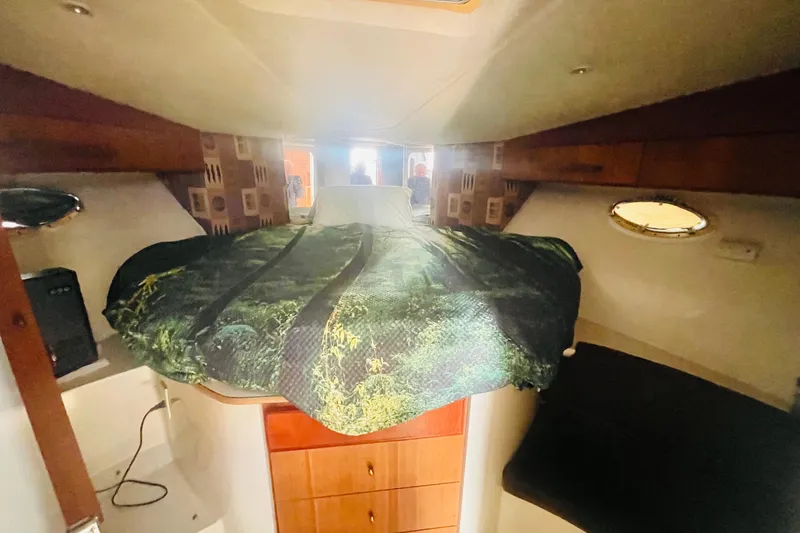 Slide: The Image of Interior cabin of a 1995 Silverton 36 Convertible boat with cozy bedding. - 16