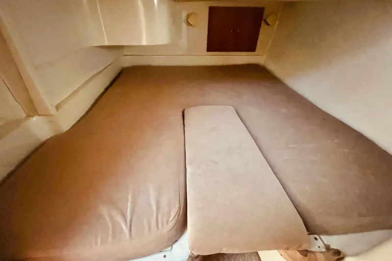 Slide: The Image of 1995 Silverton 36 Convertible cabin interior with brown cushions and compact storage space. - 17