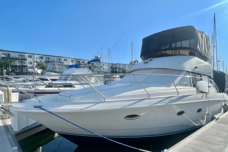 Slide: The Image of 1995 Silverton 36 Convertible yacht docked at marina under clear blue sky. - 3
