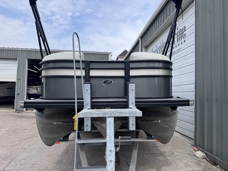 Slide: The Image of 2021 Barletta Boats 23UC pontoon boat on trailer outside warehouse. - 3