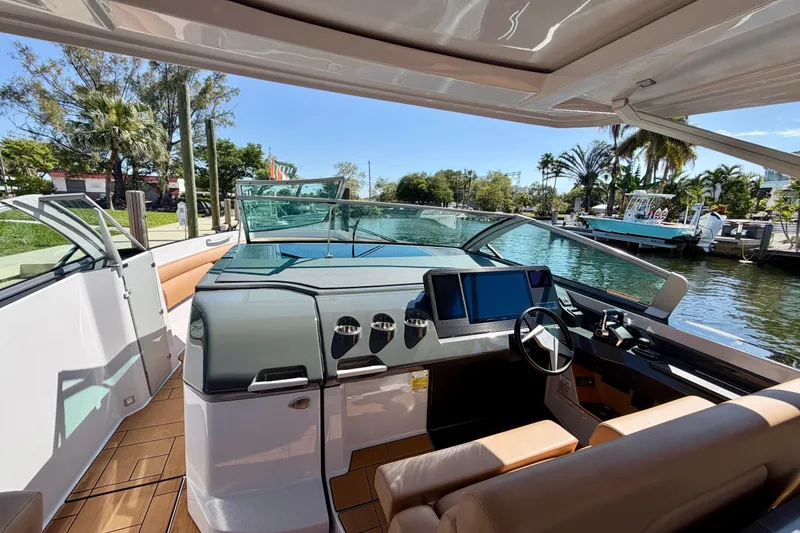 Slide: The Image of 2023 Aviara AV40 OB boat cockpit with modern controls and waterfront view. - 19
