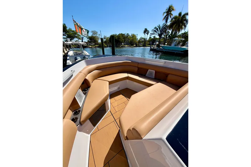 Slide: The Image of Luxurious seating on 2023 Aviara AV40 OB boat, docked by palm trees and water. - 25