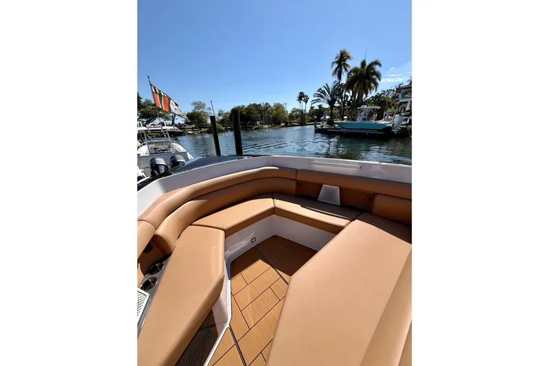 Slide: The Image of 2023 Aviara AV40 OB boat with tan seating, docked by a scenic waterfront. - 27