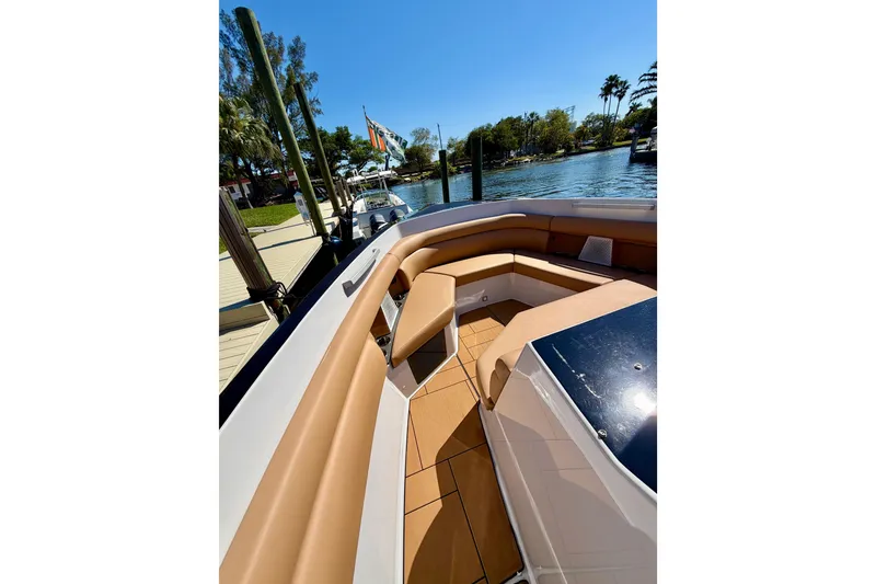 Slide: The Image of 2023 Aviara AV40 OB boat with tan seating, docked by a scenic waterfront. - 28