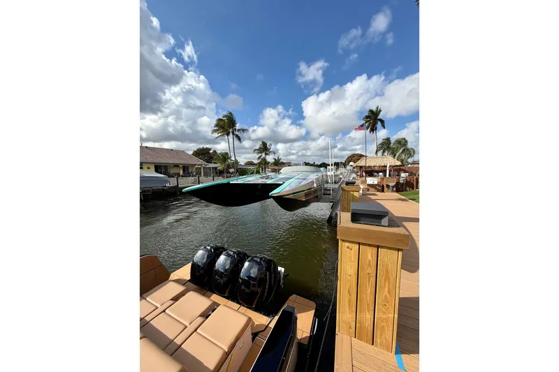 Slide: The Image of 2023 Aviara AV40 OB boat docked by a wooden pier under a partly cloudy sky. - 3