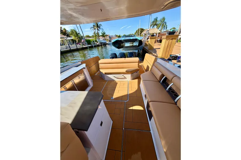 Slide: The Image of 2023 Aviara AV40 OB boat interior with tan seating, docked by a scenic waterfront. - 40