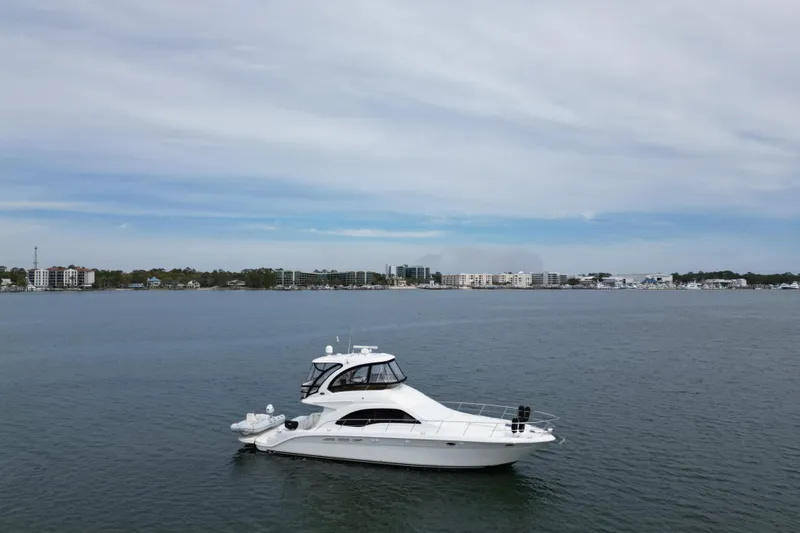 Slide: The Image of 2007 Sea Ray 52 Sedan Bridge yacht cruising on calm waters under a cloudy sky. - 10