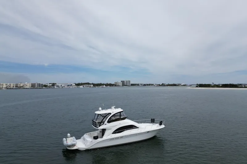 Slide: The Image of 2007 Sea Ray 52 Sedan Bridge yacht cruising on calm waters under a cloudy sky. - 11