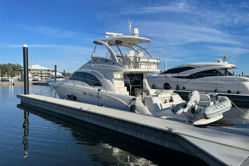 Slide: The Image of 2007 Sea Ray 52 Sedan Bridge yacht docked at marina under clear blue sky. - 12