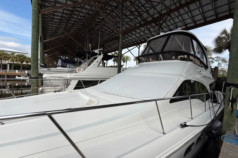 Slide: The Image of 2007 Sea Ray 52 Sedan Bridge yacht docked under a covered marina. - 14