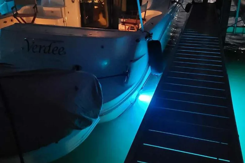 Slide: The Image of 2007 Sea Ray 52 Sedan Bridge docked at night with blue underwater lights. - 15
