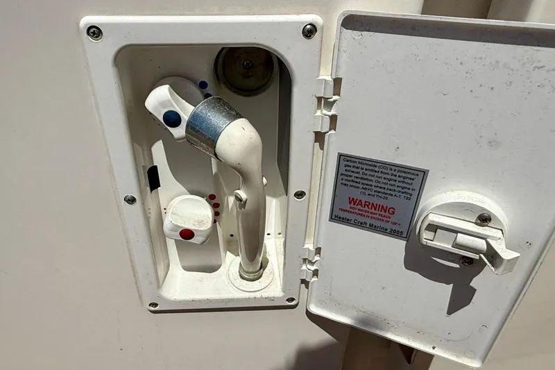 Slide: The Image of 2007 Sea Ray 52 Sedan Bridge water outlet with warning label and control handle. - 17