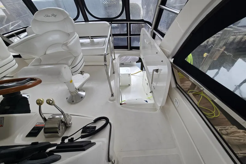 Slide: The Image of 2007 Sea Ray 52 Sedan Bridge helm with white seating and control panel. - 21