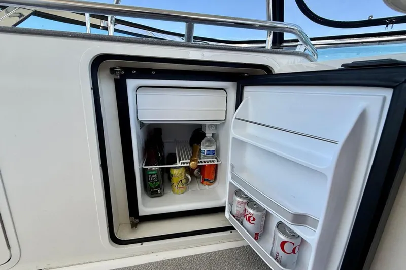 Slide: The Image of Open mini fridge on 2007 Sea Ray 52 Sedan Bridge, stocked with drinks. - 26