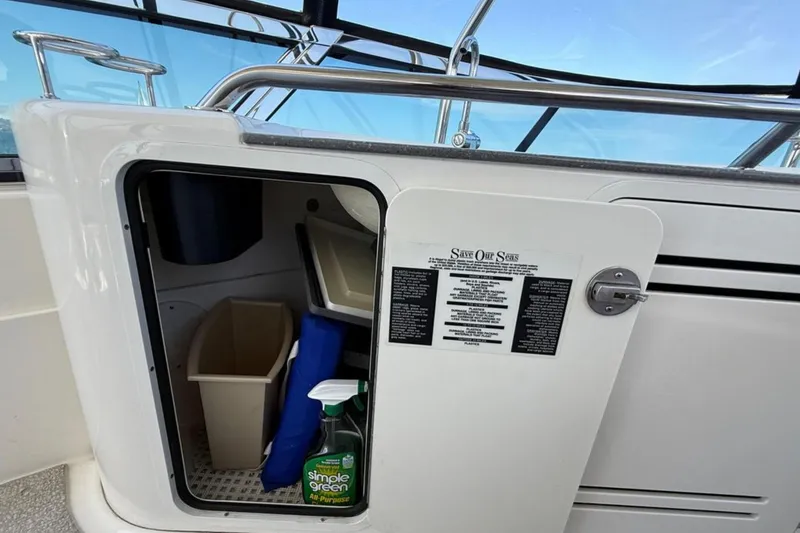 Slide: The Image of 2007 Sea Ray 52 Sedan Bridge storage compartment with cleaning supplies and waste bin. - 27