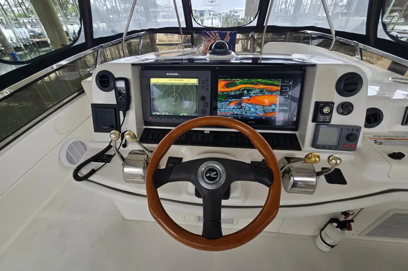 Slide: The Image of 2007 Sea Ray 52 Sedan Bridge helm with advanced navigation systems and wooden steering wheel. - 29