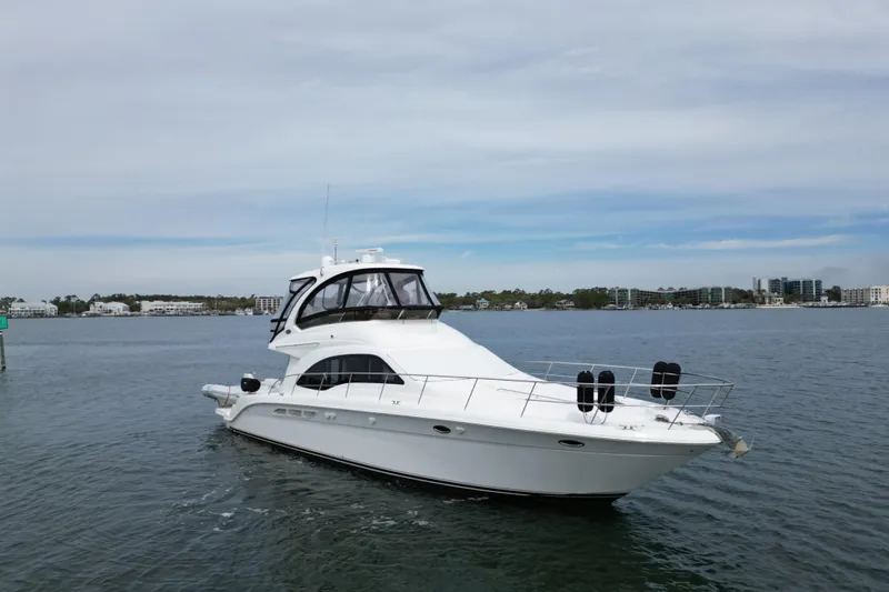 Slide: The Image of 2007 Sea Ray 52 Sedan Bridge yacht on calm waters, with cityscape in background. - 3