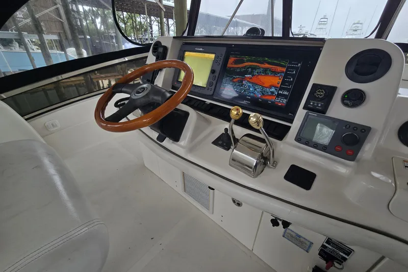 Slide: The Image of 2007 Sea Ray 52 Sedan Bridge helm with navigation screens and wooden steering wheel. - 30