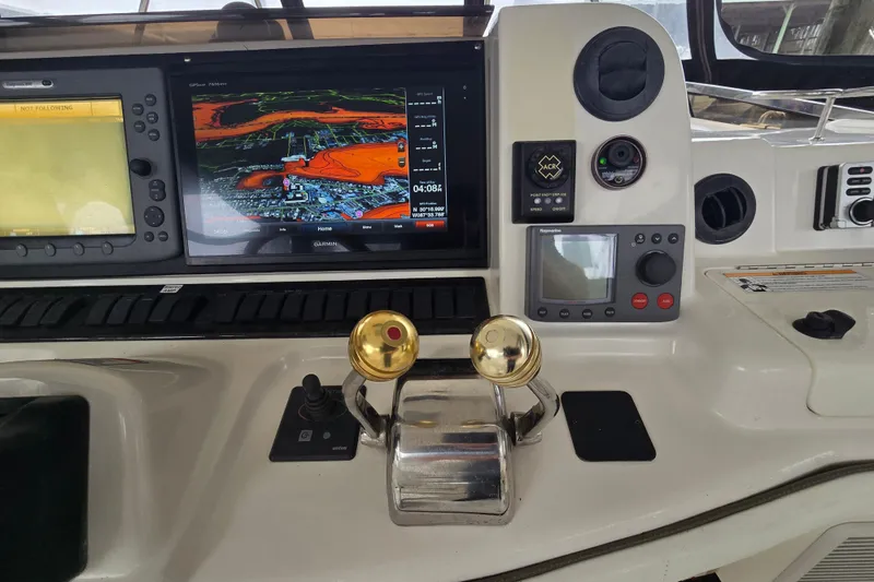 Slide: The Image of 2007 Sea Ray 52 Sedan Bridge helm with navigation screens and controls. - 32