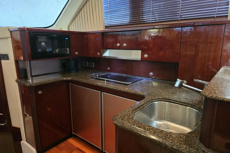 Slide: The Image of Luxurious 2007 Sea Ray 52 Sedan Bridge yacht kitchen with modern appliances and elegant wood cabinetry. - 47