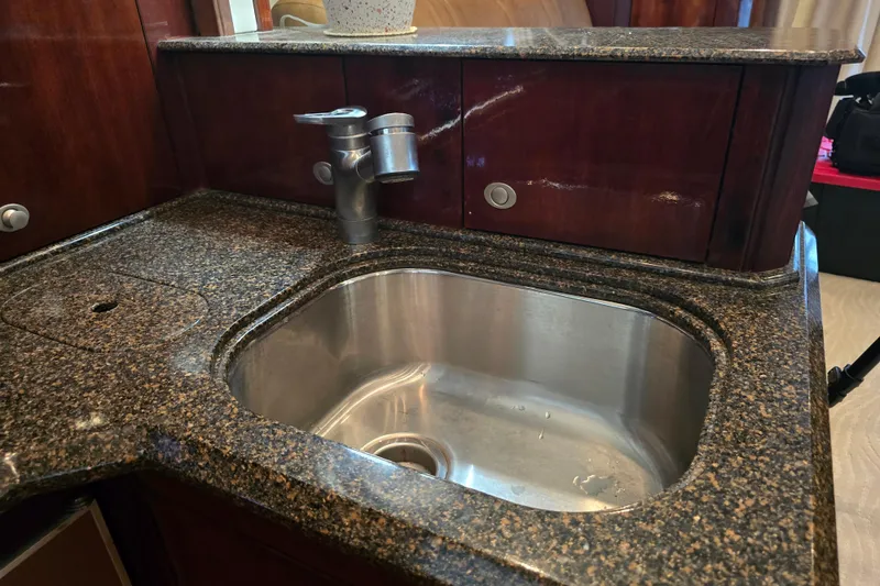 Slide: The Image of Luxurious kitchen sink in 2007 Sea Ray 52 Sedan Bridge yacht with granite countertop. - 48