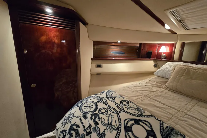 Slide: The Image of Luxurious 2007 Sea Ray 52 Sedan Bridge cabin interior with cozy bedding and elegant wood finishes. - 63