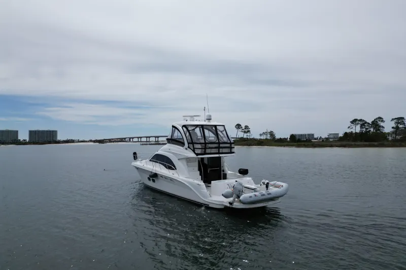 Slide: The Image of 2007 Sea Ray 52 Sedan Bridge yacht on calm water near shoreline. - 7