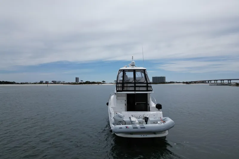 Slide: The Image of 2007 Sea Ray 52 Sedan Bridge yacht on calm water with cityscape background. - 8